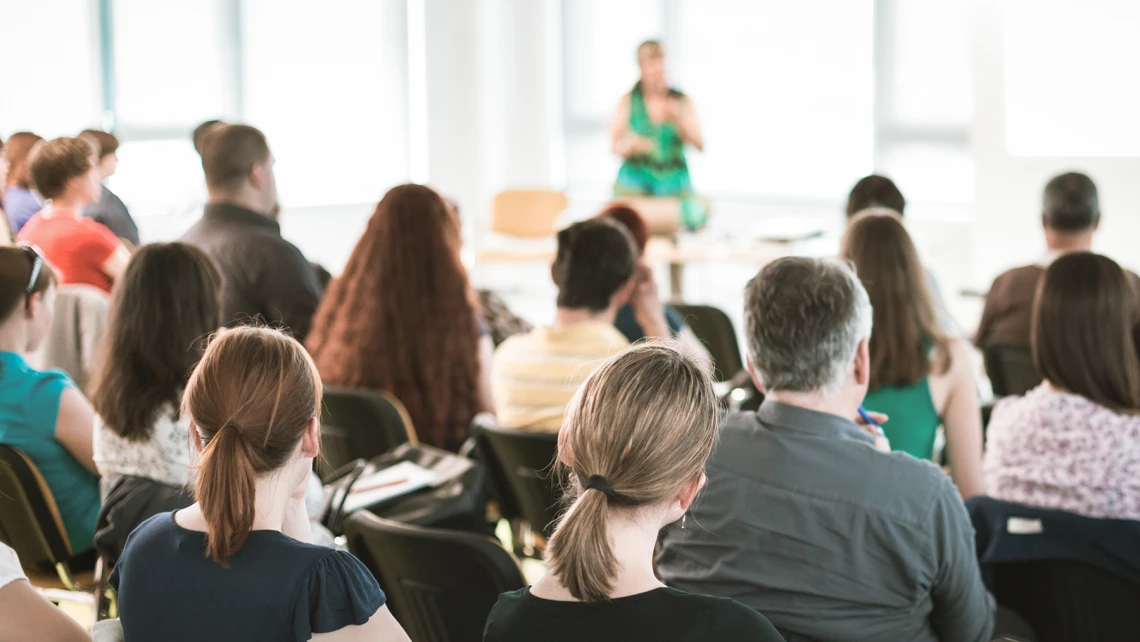 unrecognizable female speaker in front of audience